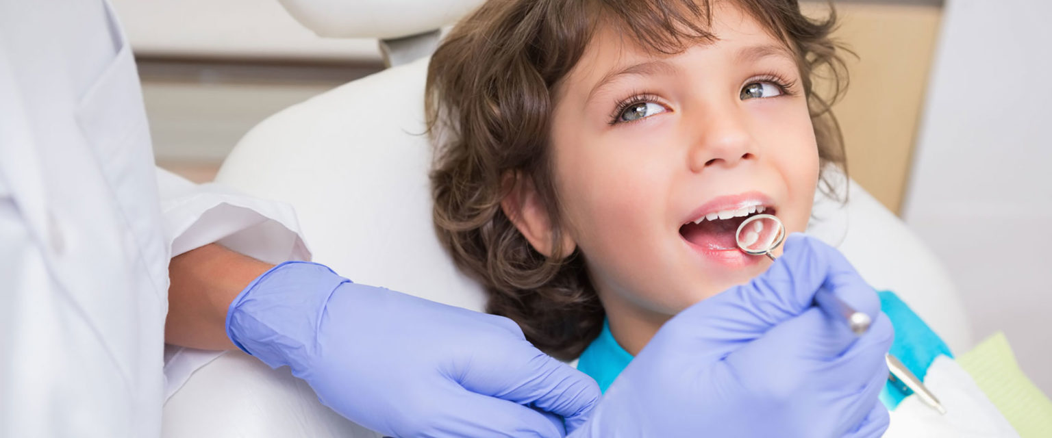 Junger lächelnder Patient bei der Behandlung seiner Zähne.