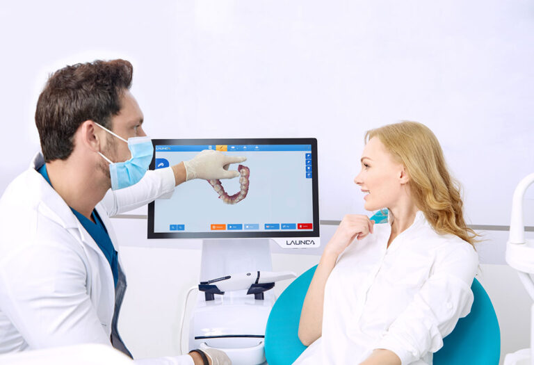 Zahnarzt zeigt Patientin 3D-Scanaufnahme über Bildschirm