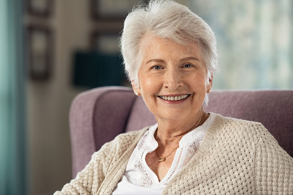 Glückliche Seniorin im Wohnzimmer