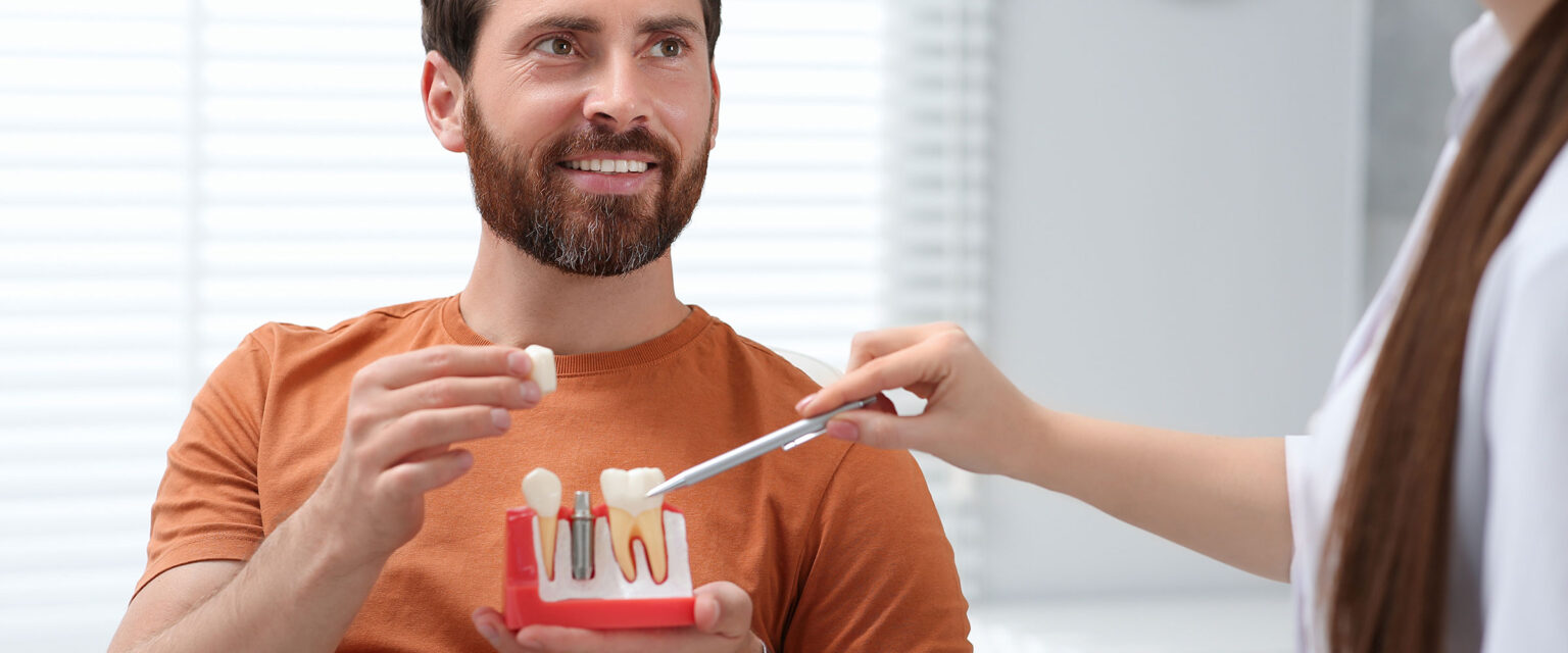 Mann bei Zahnimplantat-Beratung