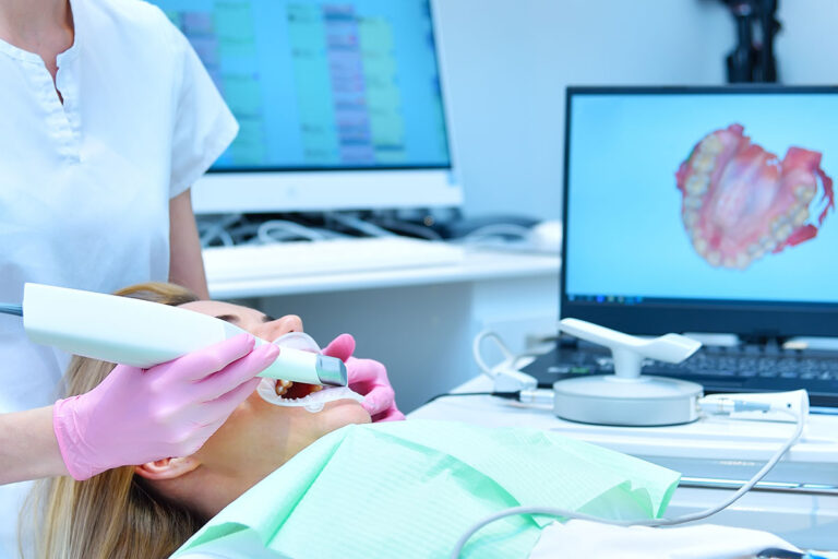Zahnärztin bei der Behandlung mit einem Intraoral-Scanner