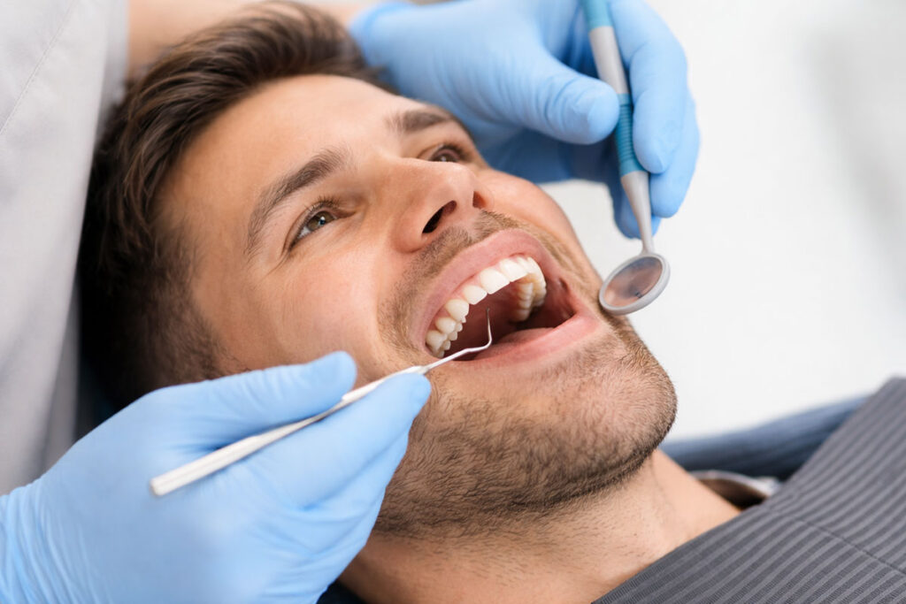 Mann bekommt eine Professionelle Zahnreinigung